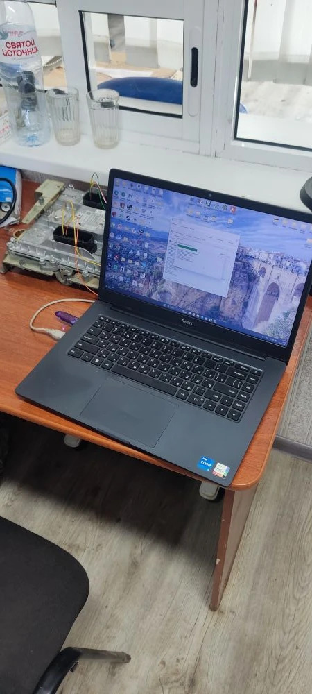 Инженер ТракСистемс с ноутбуком и блоком управления спецтехники